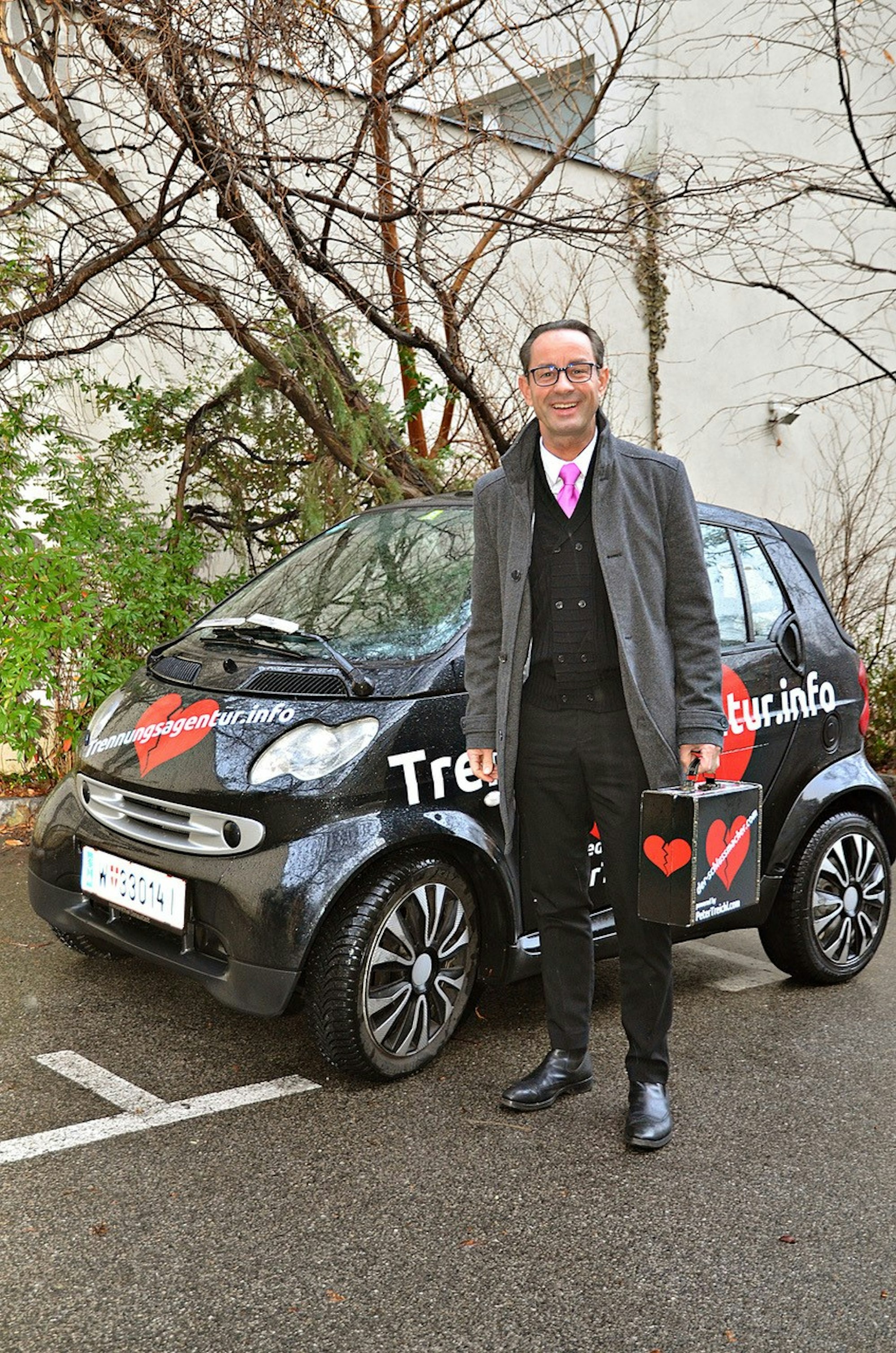 Trennungsagentur Herr Treichel vorm Smart mit Koffer