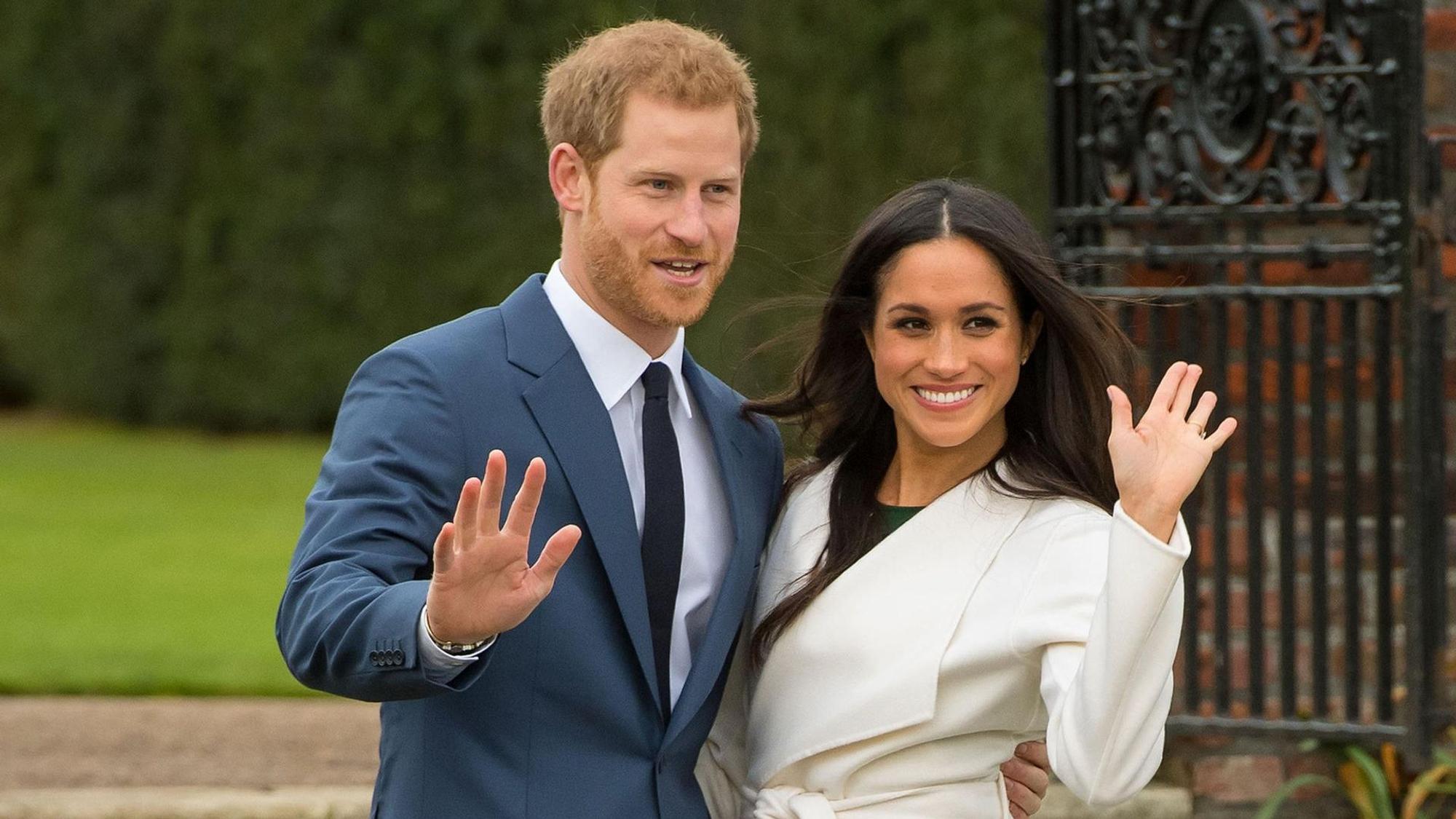 Prinz Harry und seine Frau Meghan winken.
