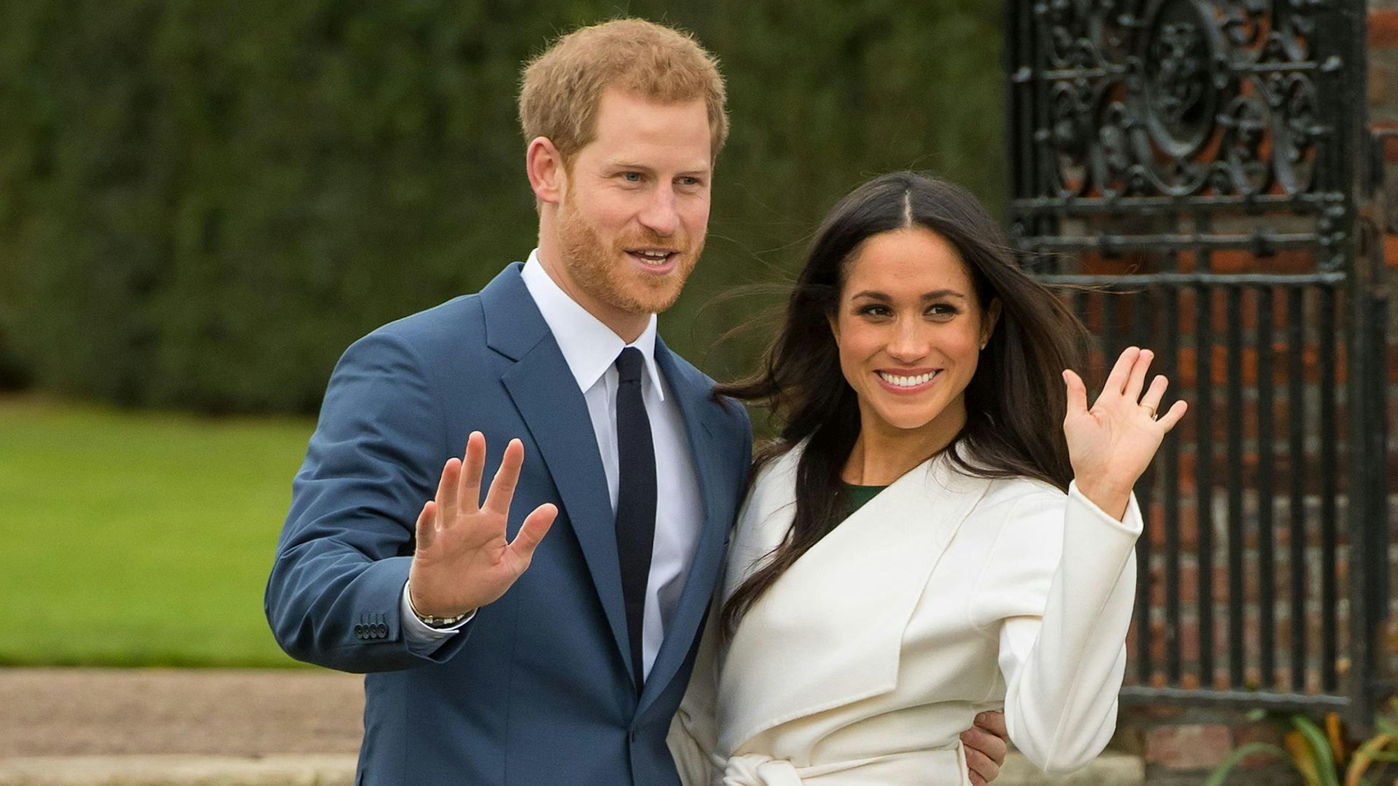 Prinz Harry und seine Frau Meghan winken.