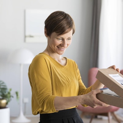 Frau_öffnet_Paket_Imago