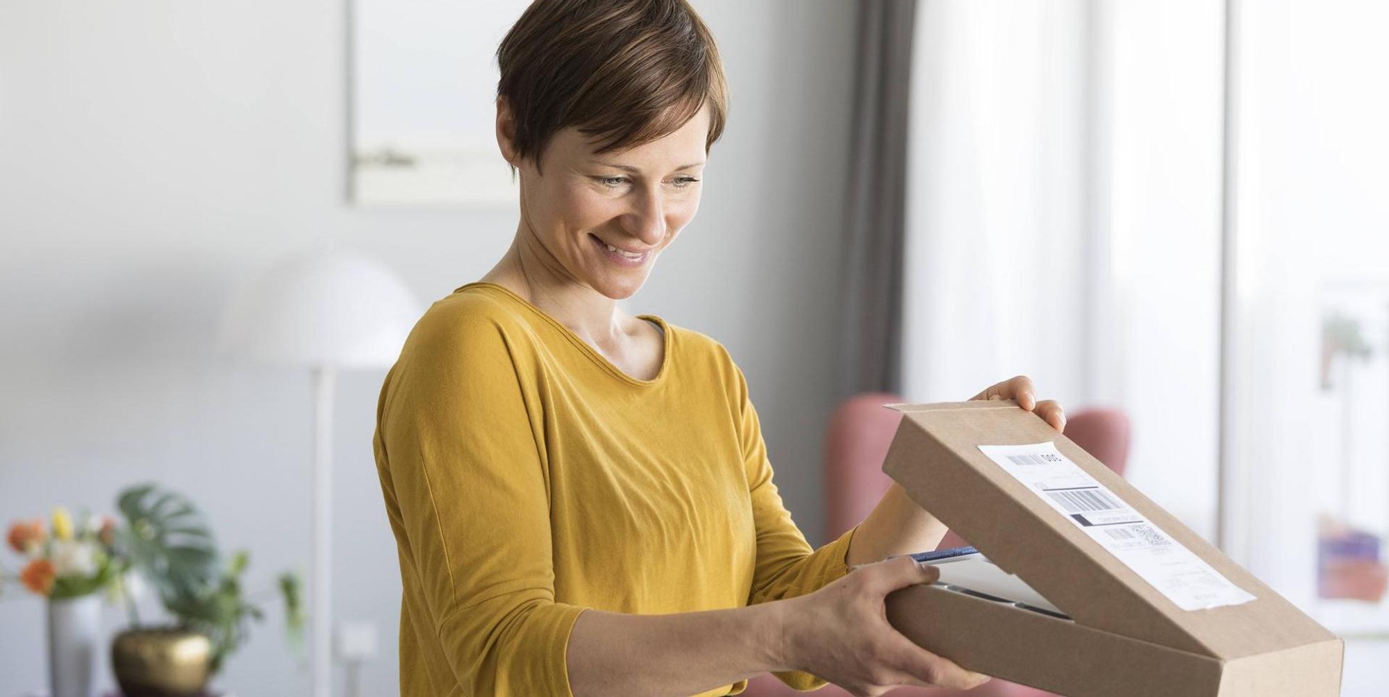Frau_öffnet_Paket_Imago