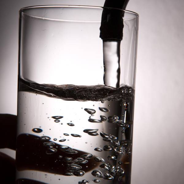 Ein Glas Wasser auf dem Wasserhahn