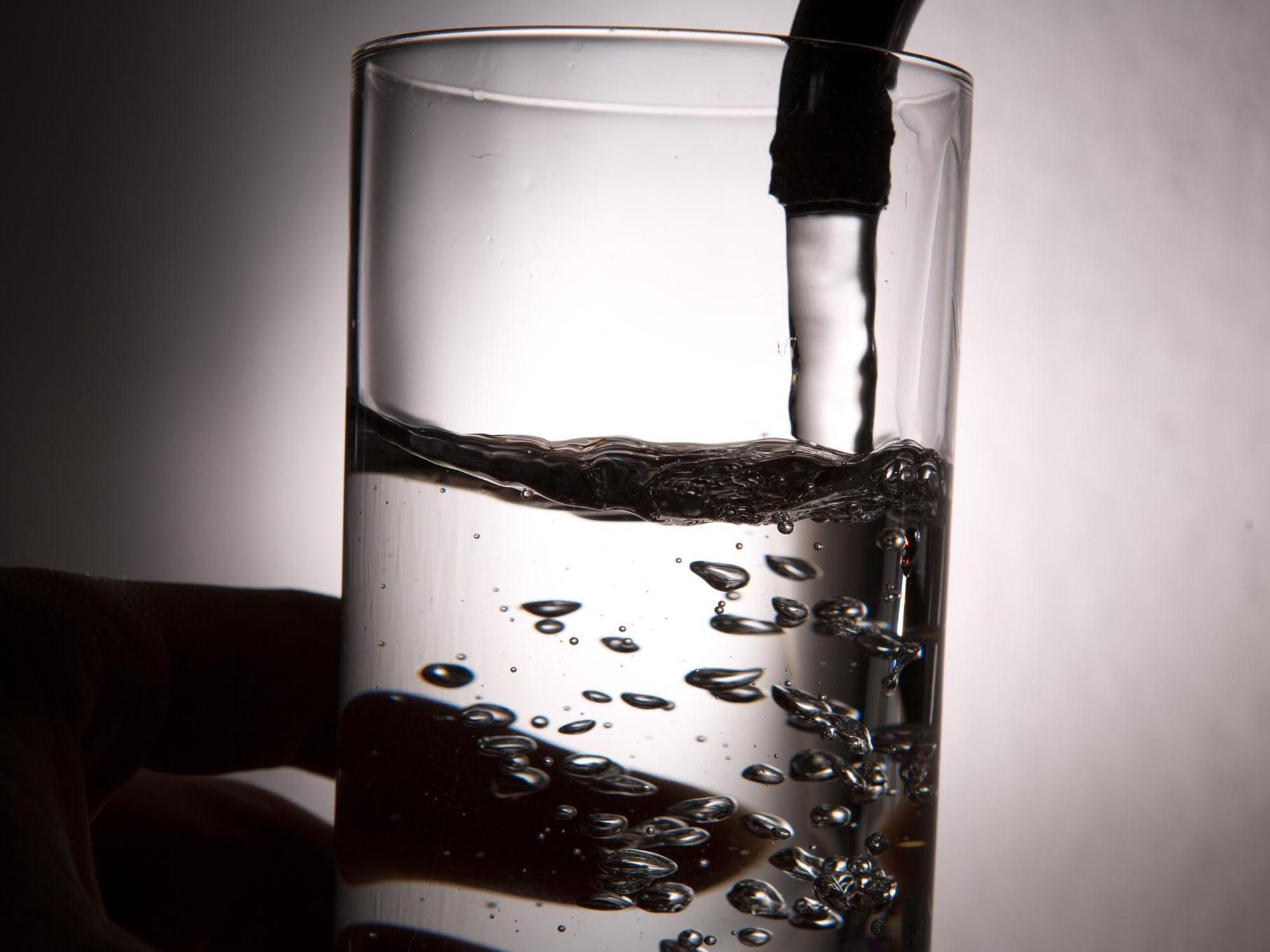 Ein Glas Wasser auf dem Wasserhahn