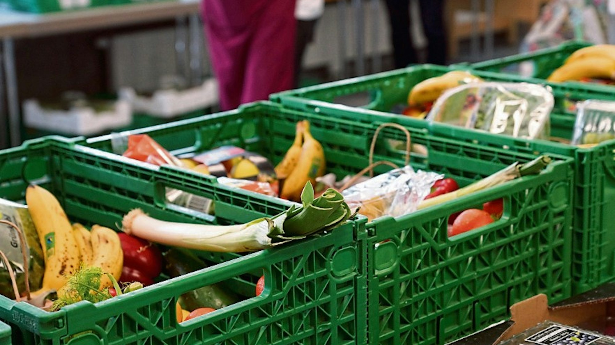 Obst und Gemüse liegen in grünen Kisten.