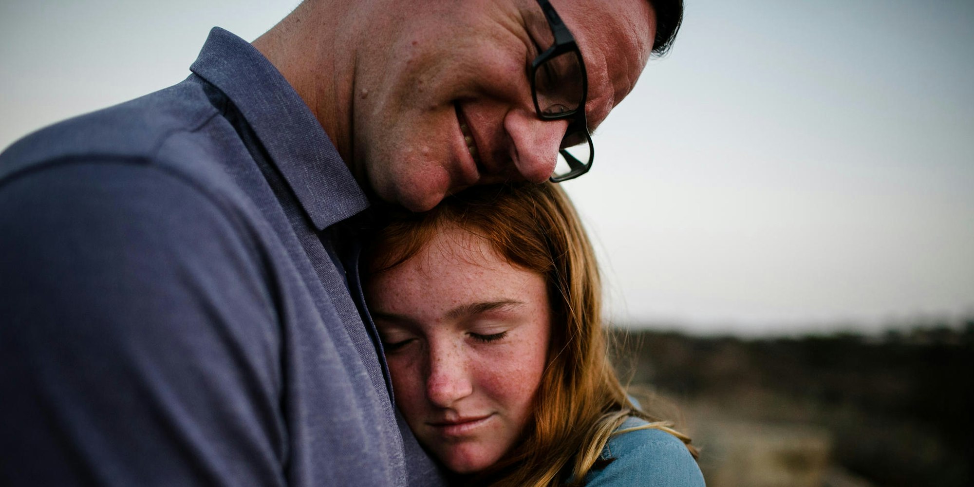 Ein Vater und seine Tochter nehmen sich in den Arm.