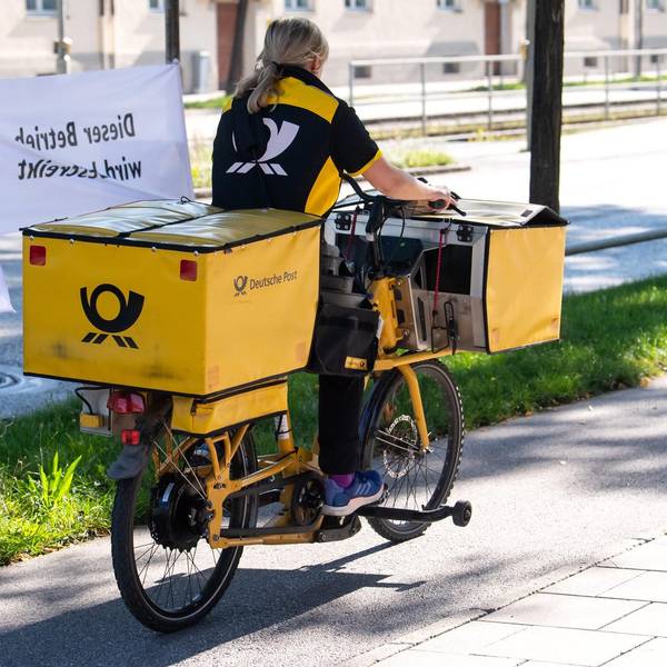 Postbotin mit Verdiflagge