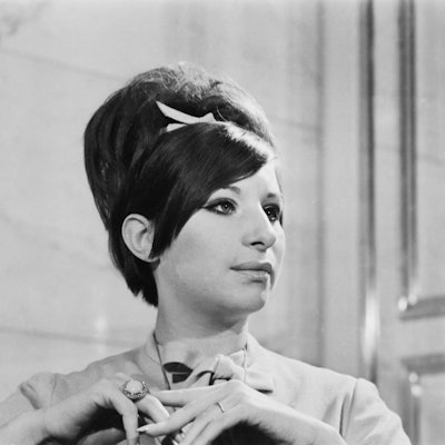 Die junge Barbra Streisand mit weißer Schleife im Haar.