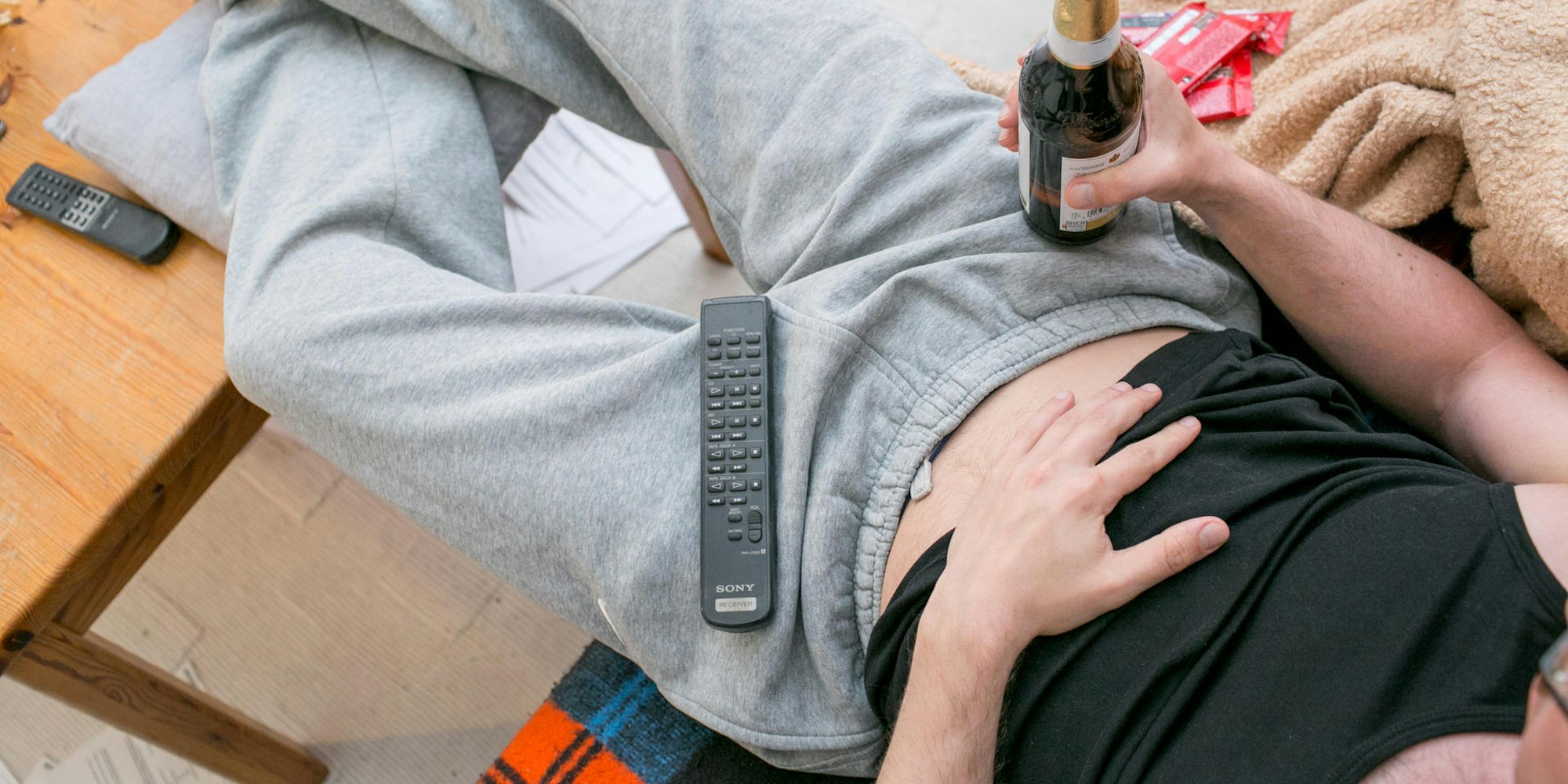 Bierbauch Jogginghose Bier Fernseher faul Symbol dpa