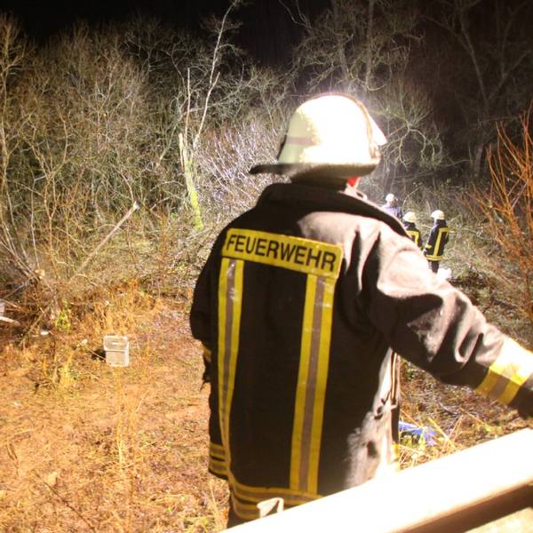 Feuerwehrleute vor einem Gebüsch