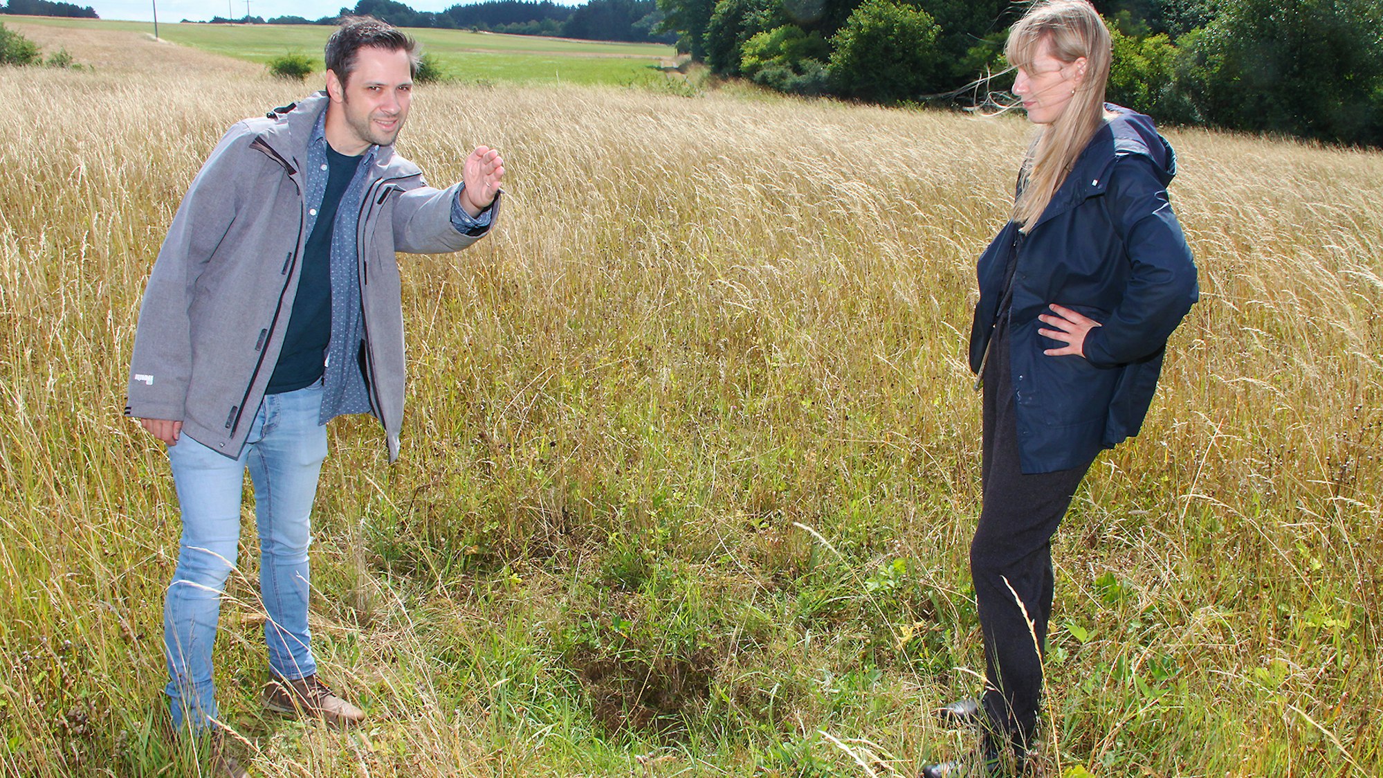 Geologe Dr. Thomas Roggenkamp und Louisa Schwartz stehen auf einer Wiese.