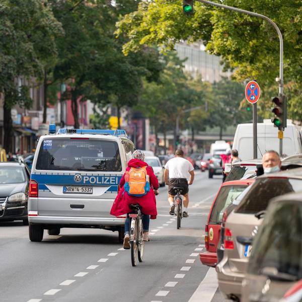 Auf der Hauptstraße sind viele Autos und Radfahrer unterwegs.