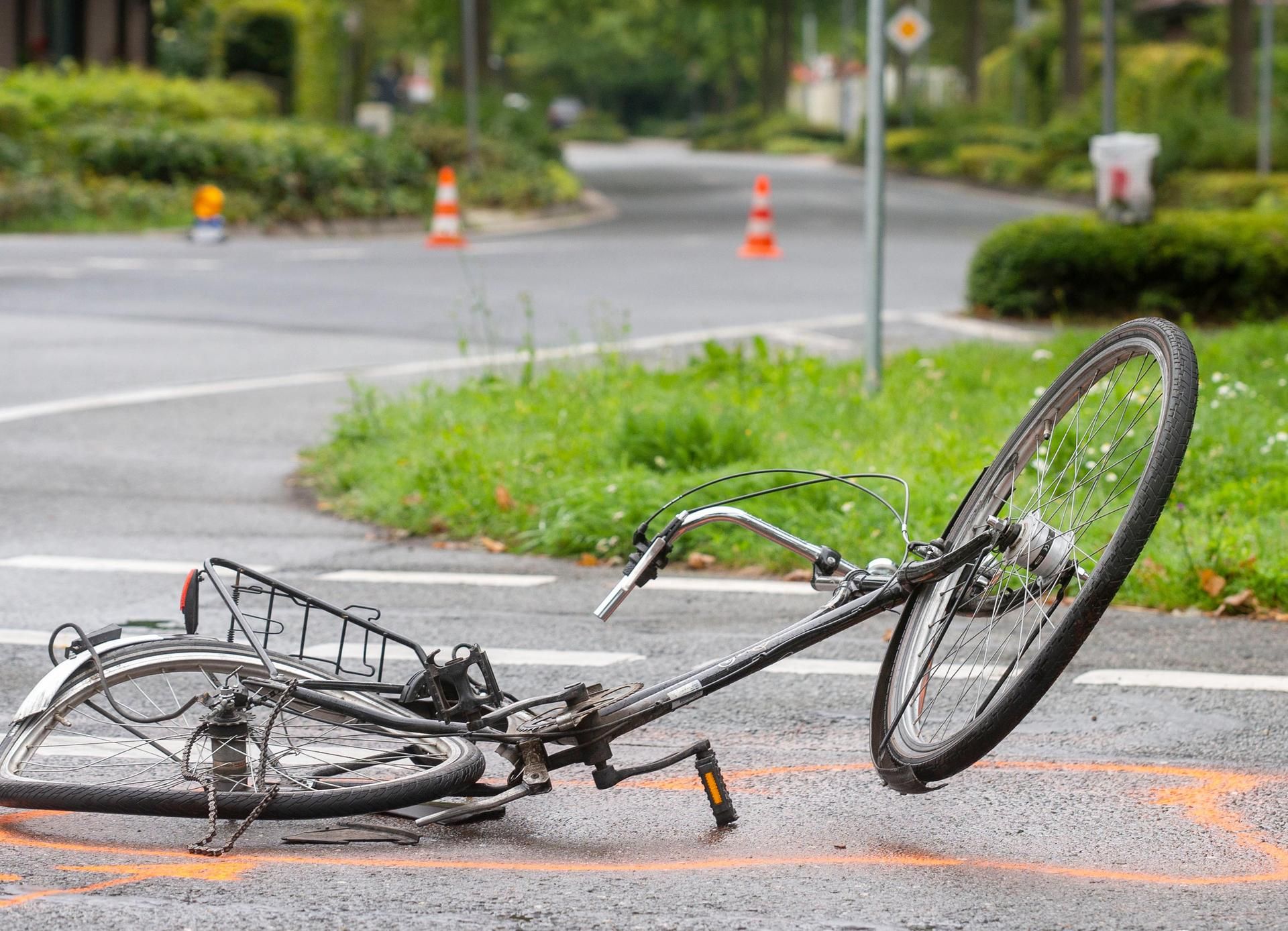 Das Bild zeigt ein Fahrrad nach einem Unfall auf einer Straße.