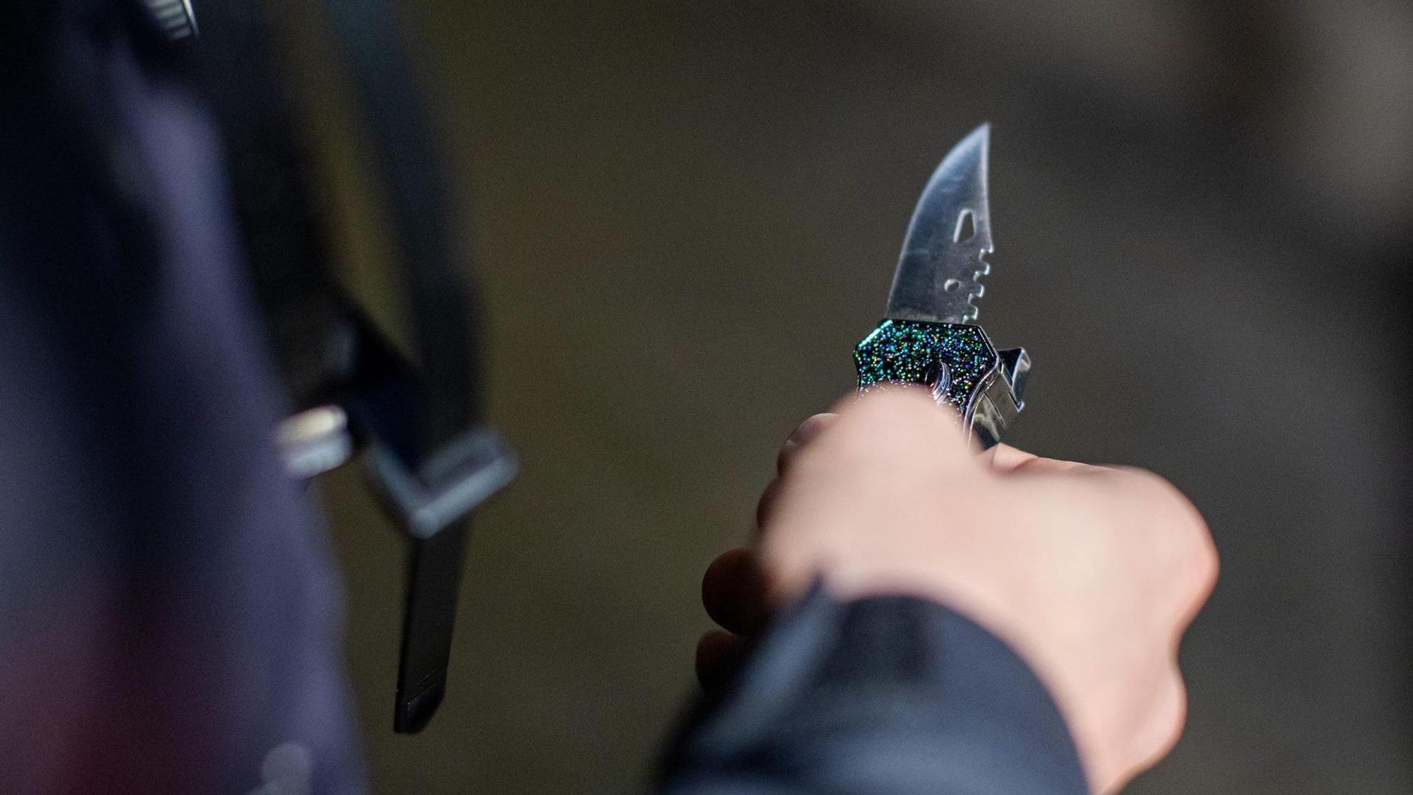 Ein Mann hat ein Messer in der Hand.