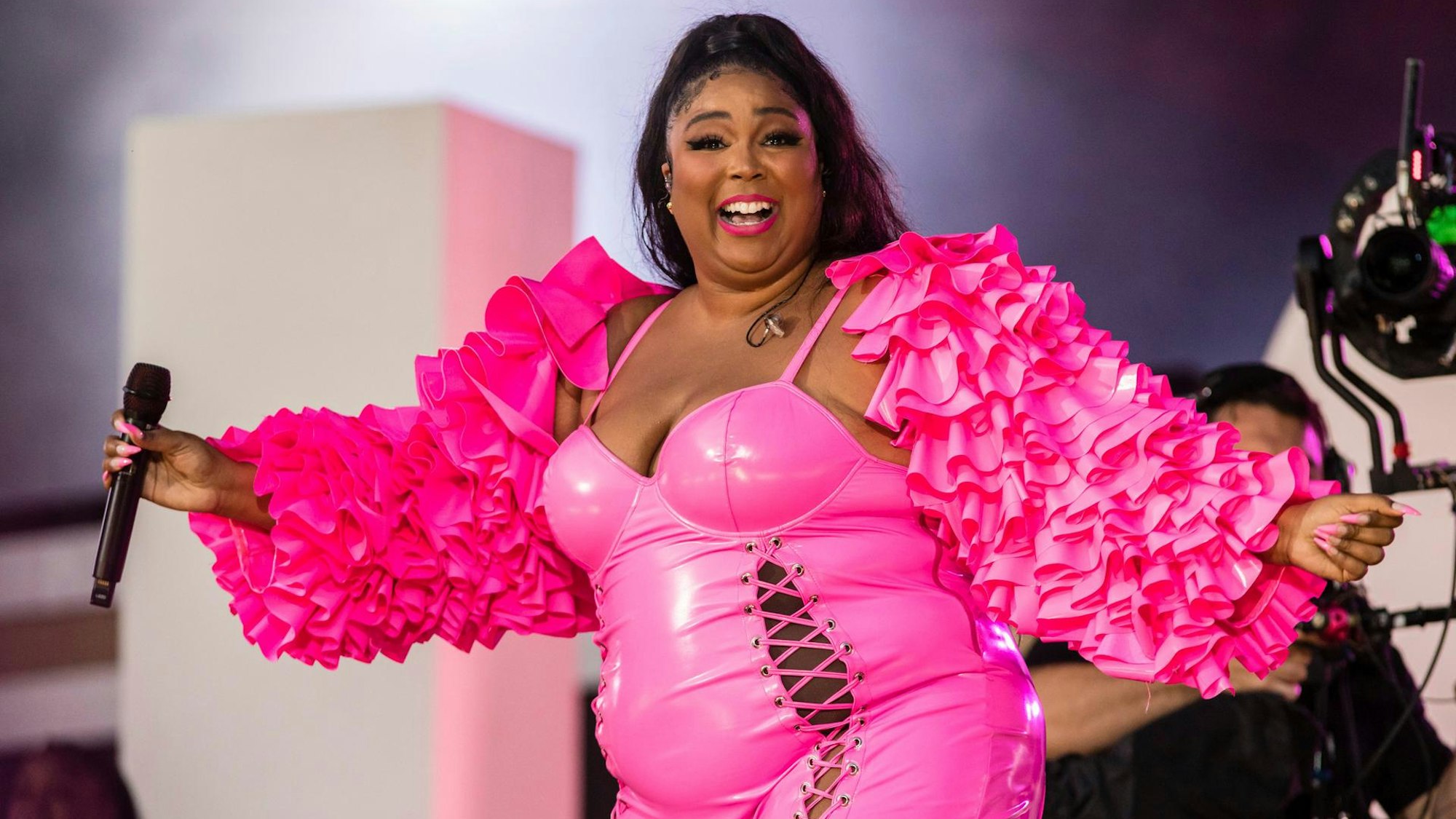 Lizzo bei einem Auftritt in New York. Sie trägt ein pinkes Outfit.