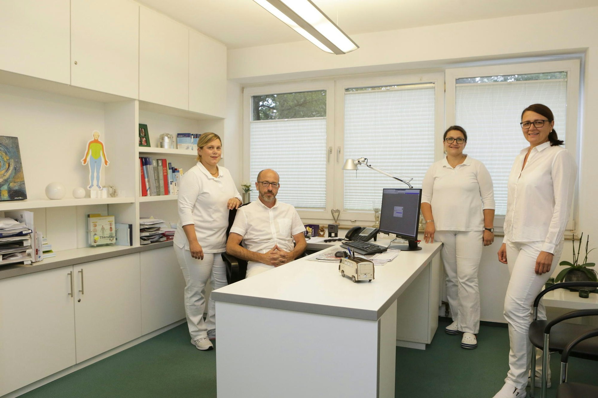 Das Team der Gemeinschaftspraxis Wippcare posiert in einem Behandlungszimmer.