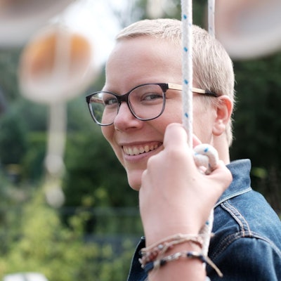 Porträtfoto von Jennifer Wagner mit Garten im Hintergrund