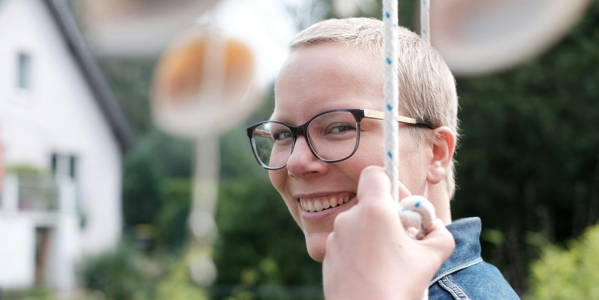 Porträtfoto von Jennifer Wagner mit Garten im Hintergrund