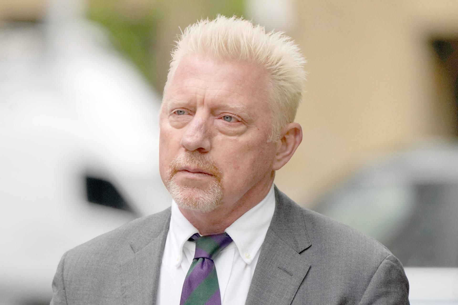 Boris Becker trägt Anyug und schaut an der Kamera vorbei.