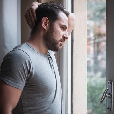 Mann steht an einem Fenster