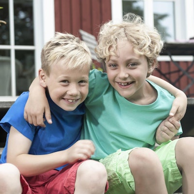 Zwei Jungs lächeln Arm in Arm