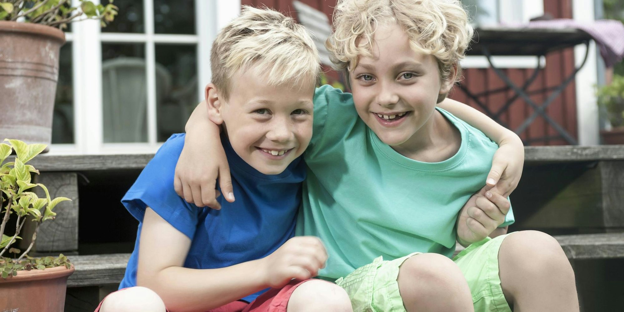 Zwei Jungs lächeln Arm in Arm