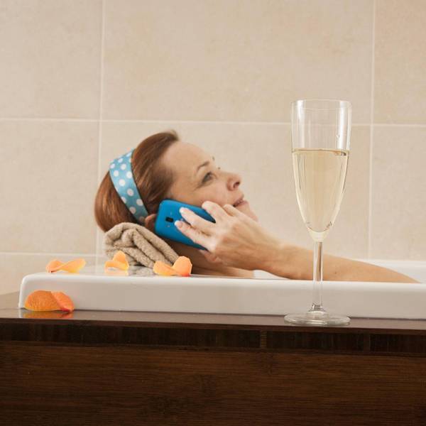 Frau mit Handy in der Wadewanne