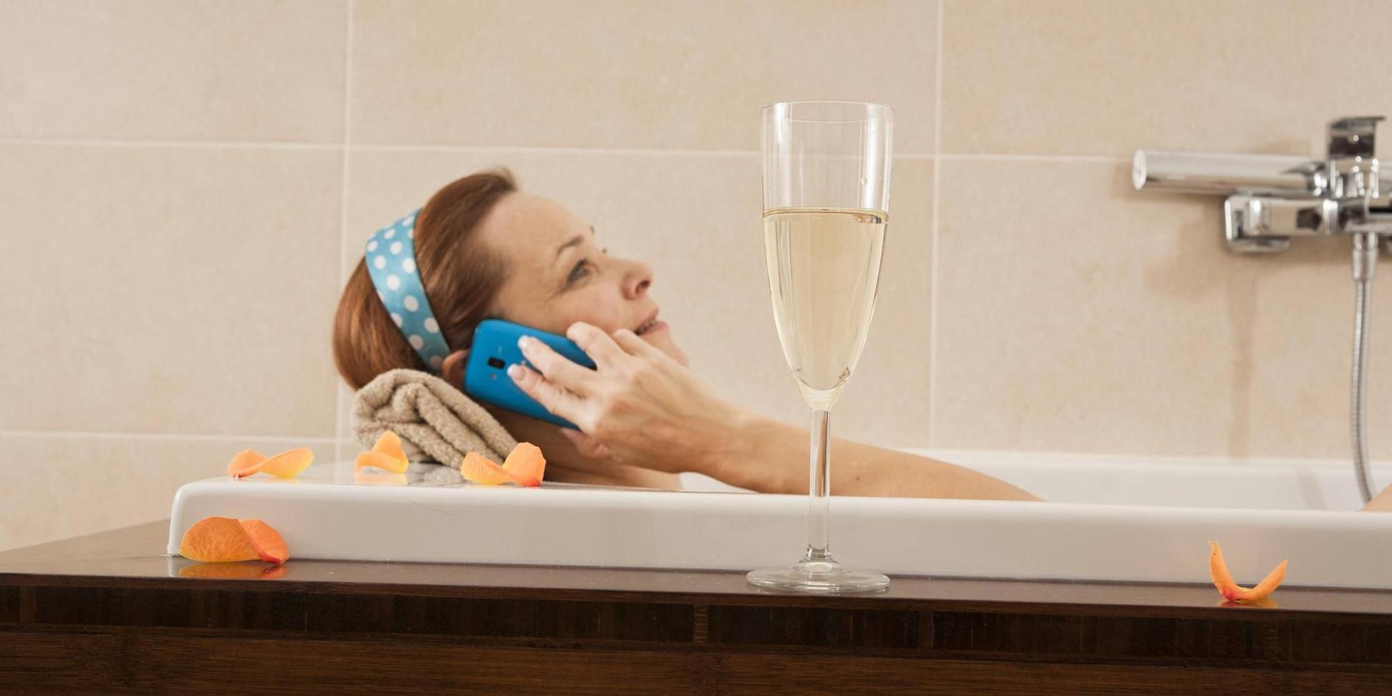 Frau mit Handy in der Wadewanne