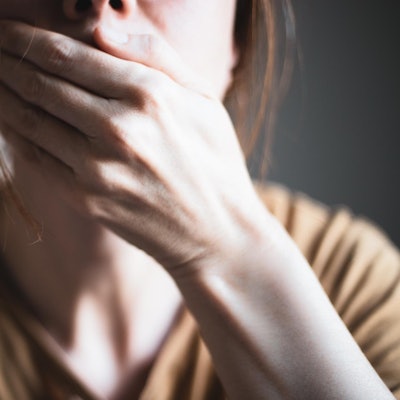 Eine Frau hält geschockt die Hand vor den Mund.