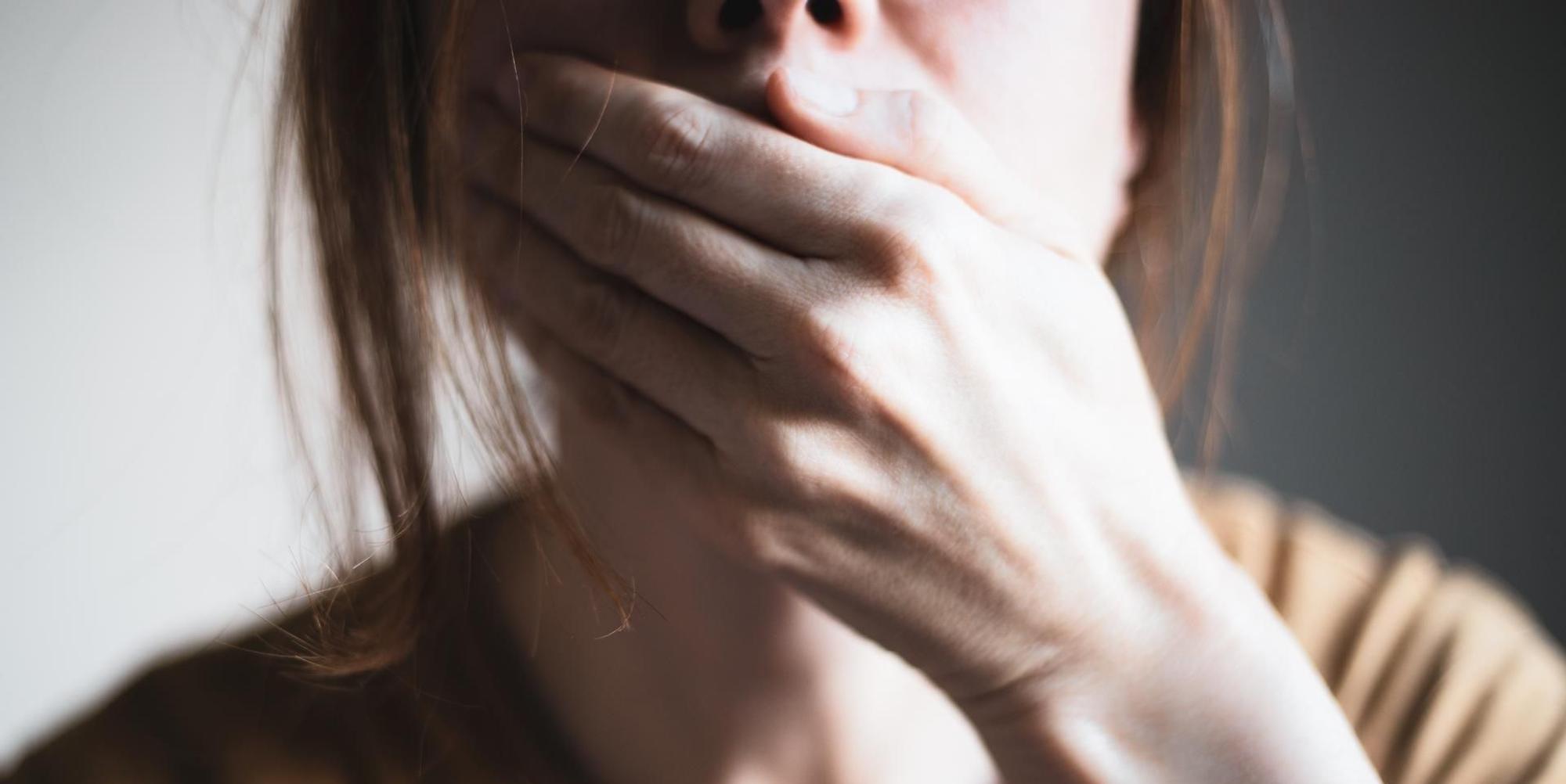 Eine Frau hält geschockt die Hand vor den Mund.