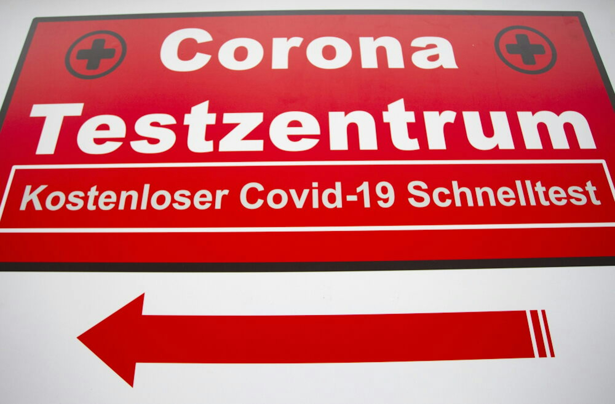Ein Schild weist auf ein Corona-Testzentrum hin.