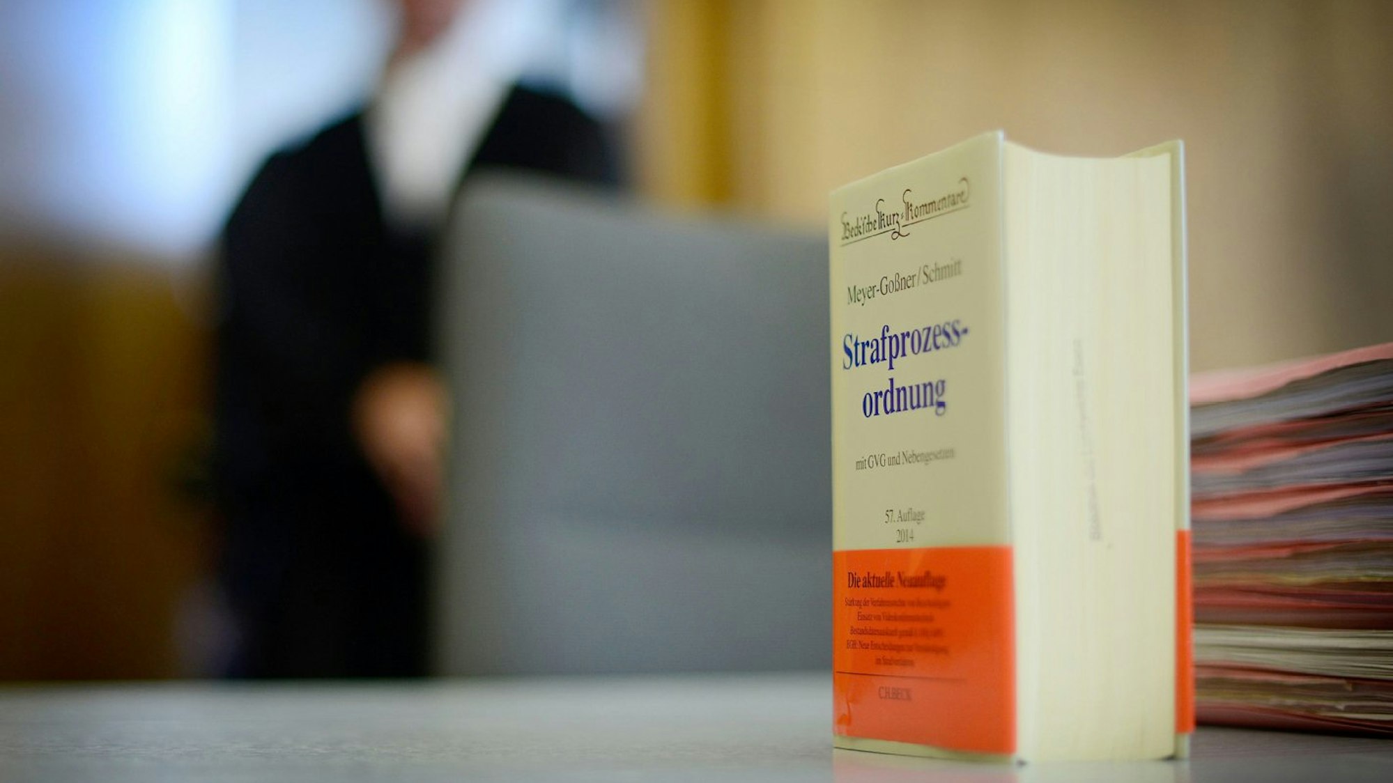 Ein Strafgesetzbuch steht auf dem Tisch eines Richters.