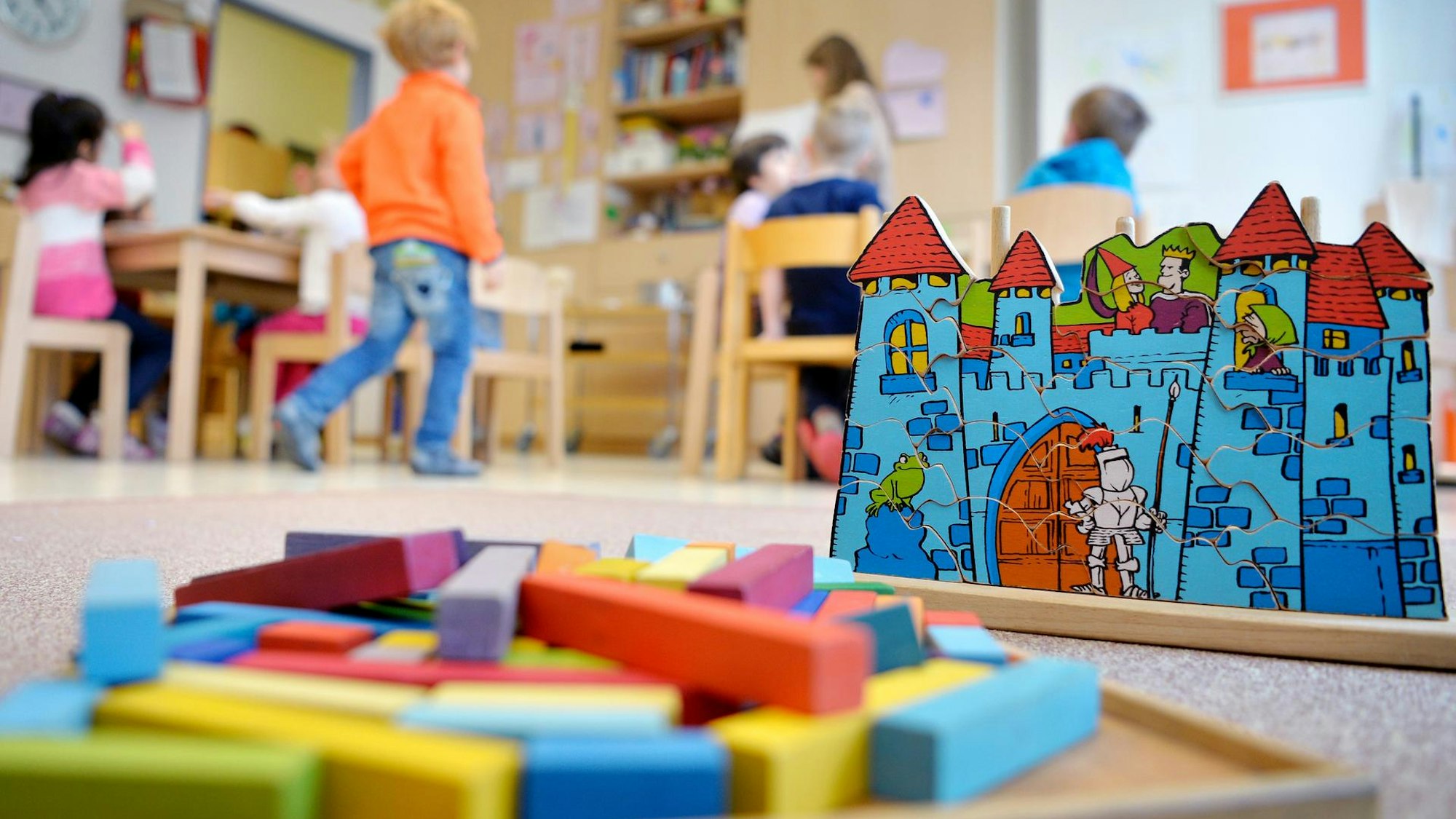 Das Foto zeigt Spielzeug in einem Kindergarten und mehrere Kinder.
