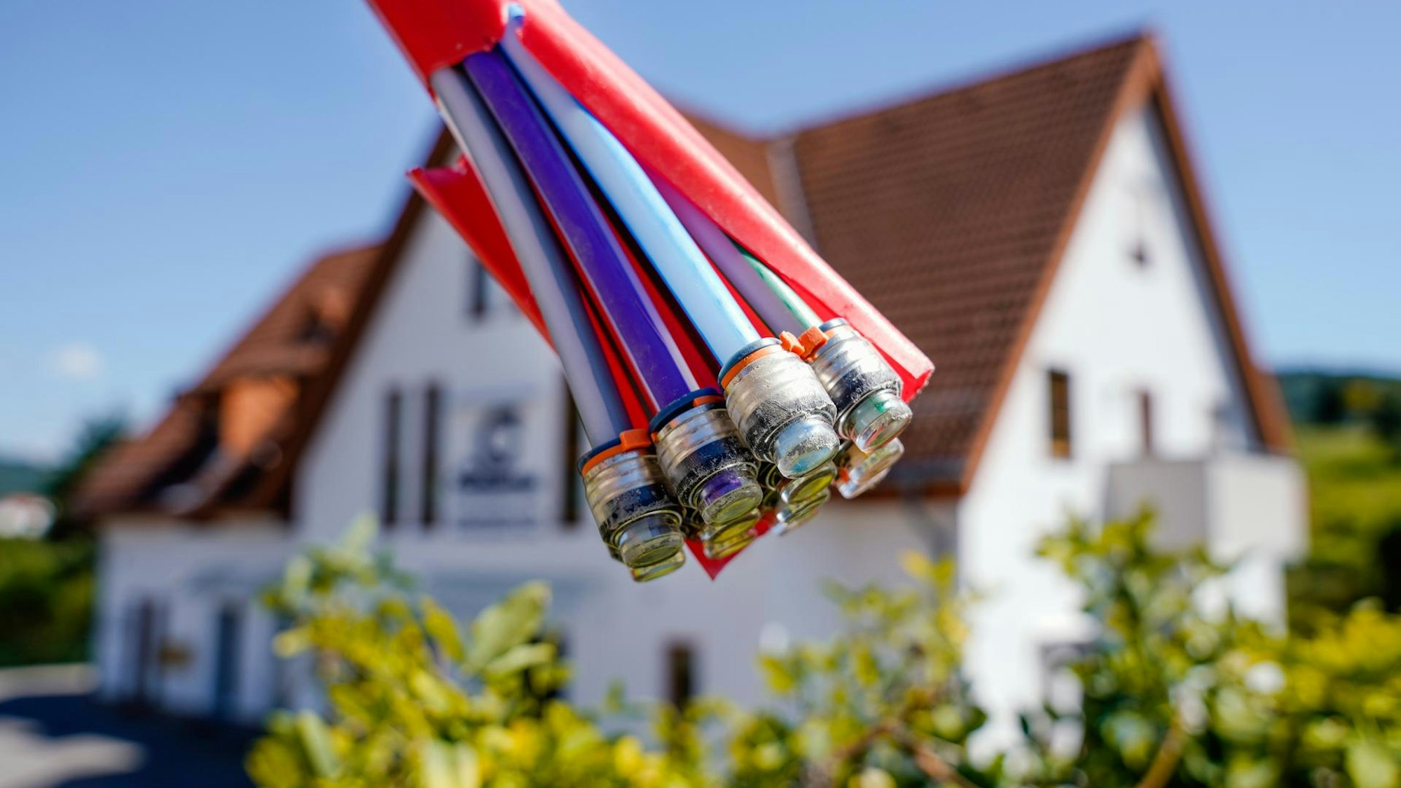 Bunte Glasfaserkabel sind vor einem Haus zu sehen.