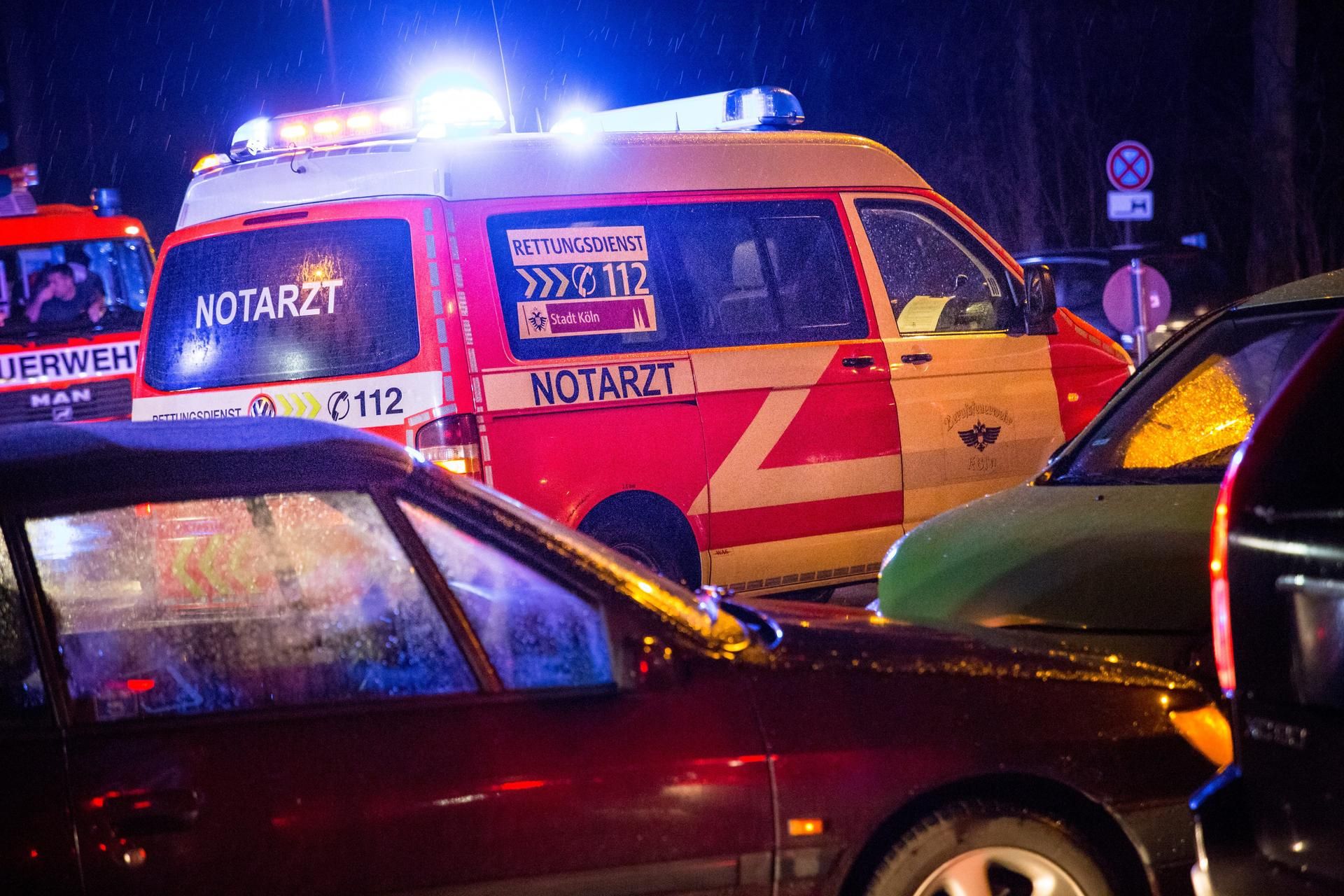 Ein Notarztwagen steht mit Blaulicht zwischen Autos