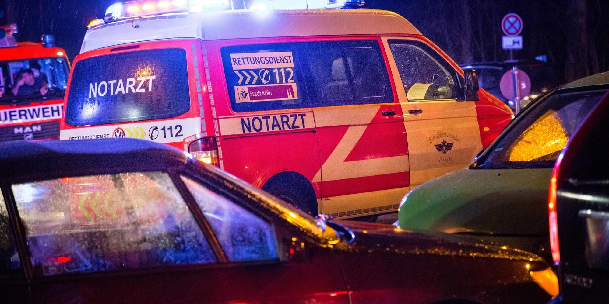 Ein Notarztwagen steht mit Blaulicht zwischen Autos