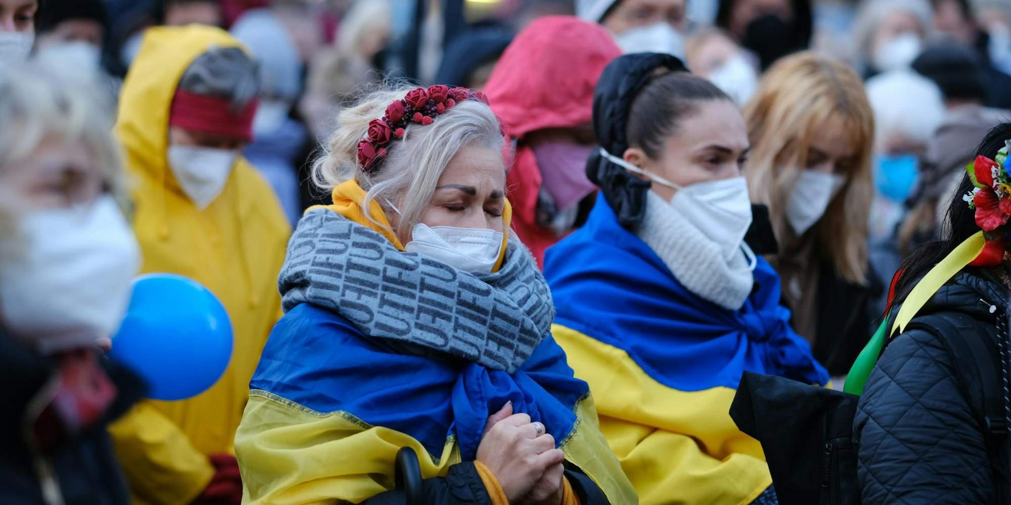 Menschen beten auf einer Friedensdemo