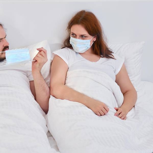 Paar mit Masken im Bett Getty Images