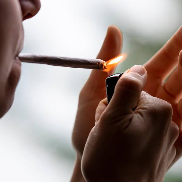 Eine Person zündet sich einen Joint an.