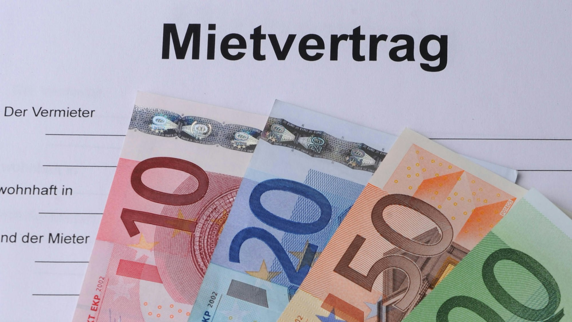 Geldscheine liegen auf einem Mietvertrag.