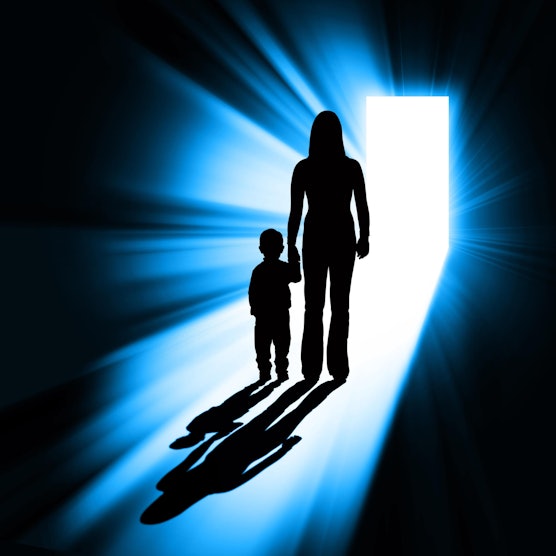 Die Silhouette einer Frau, die ein Kind an der Hand hält