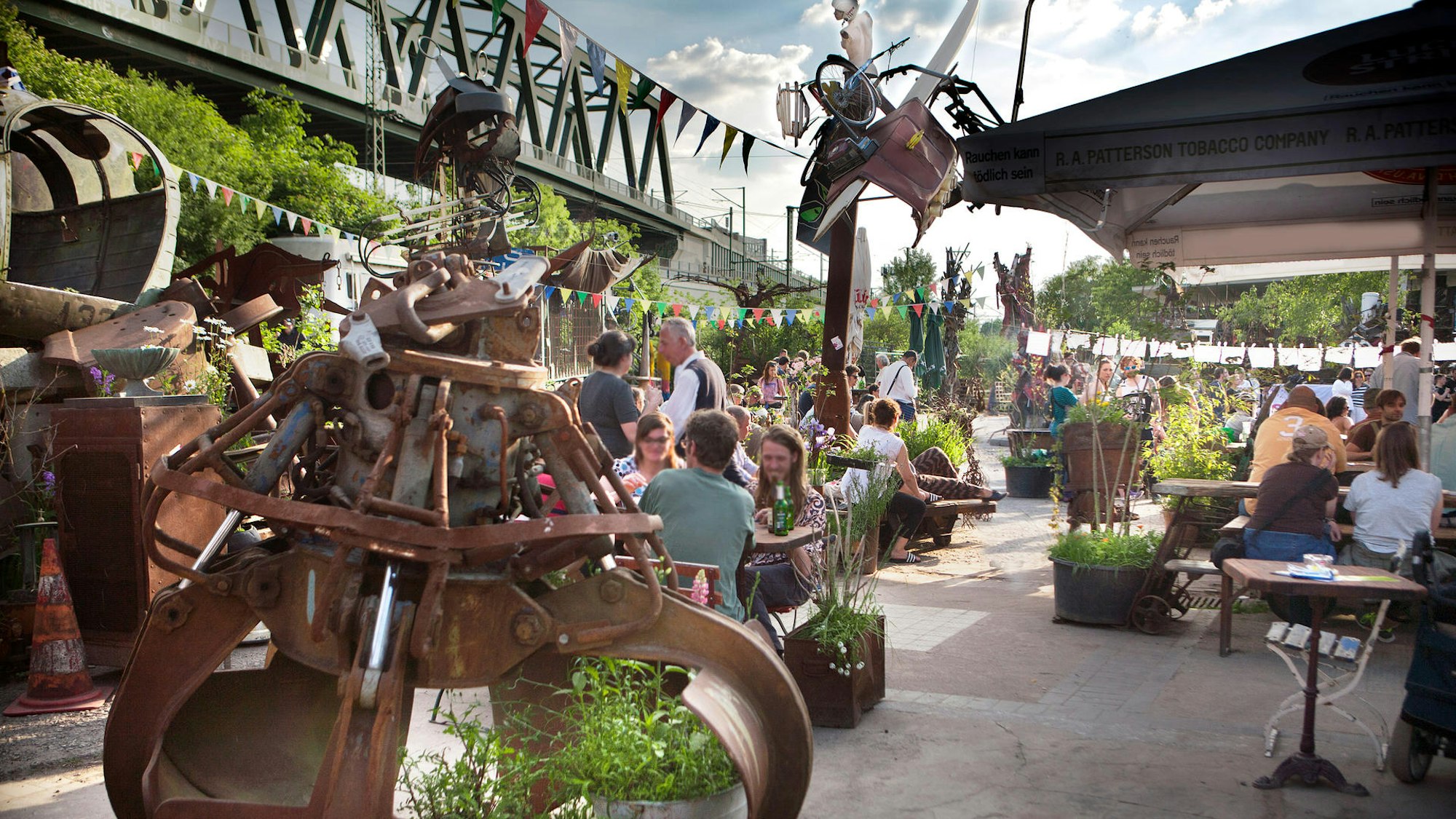 Odonien Biergarten - Bänke und Tische zwischen Skulpturen und Kunst
