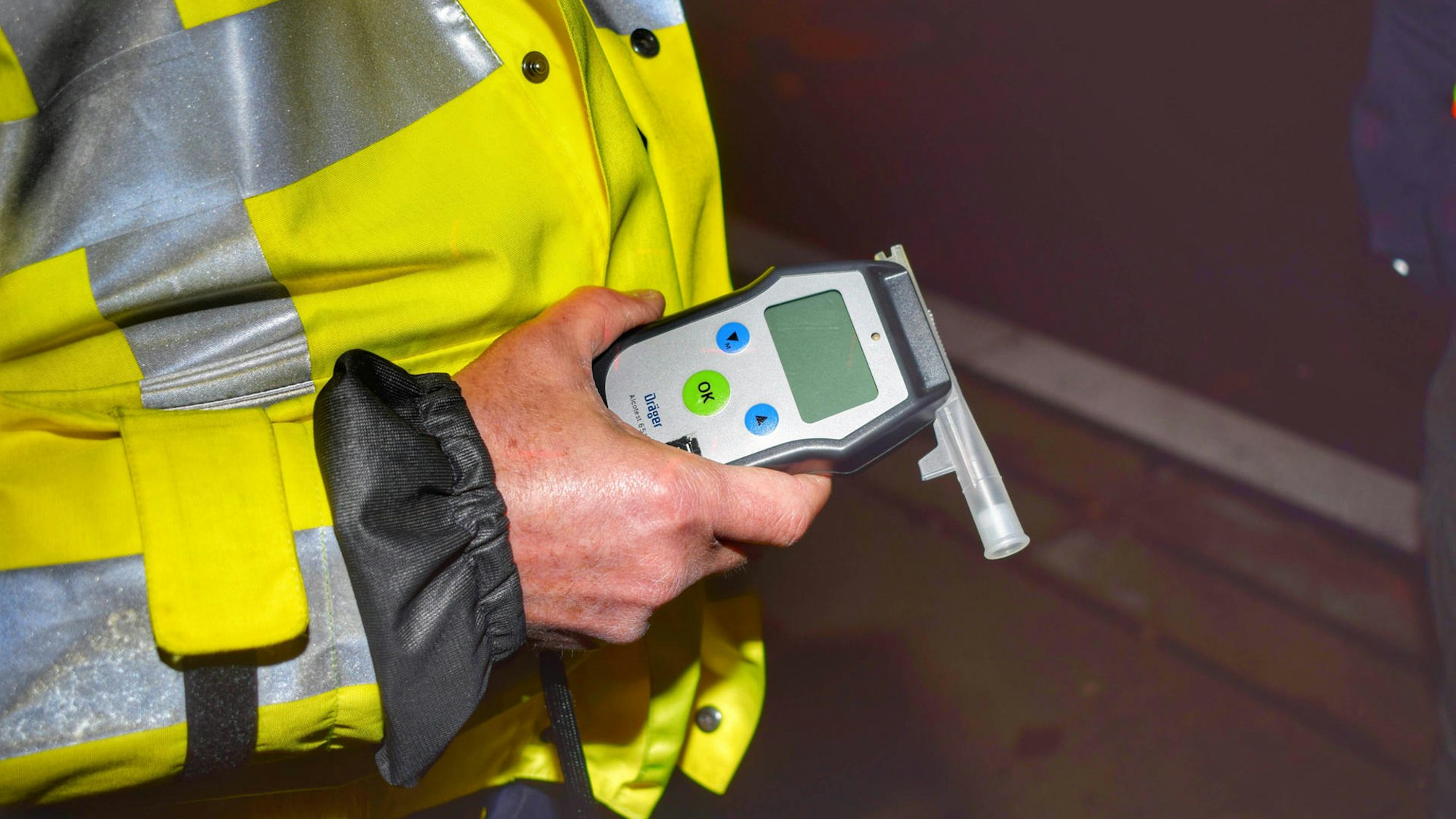 Ein Polizist hält einen Alkoholtest in der Hand.