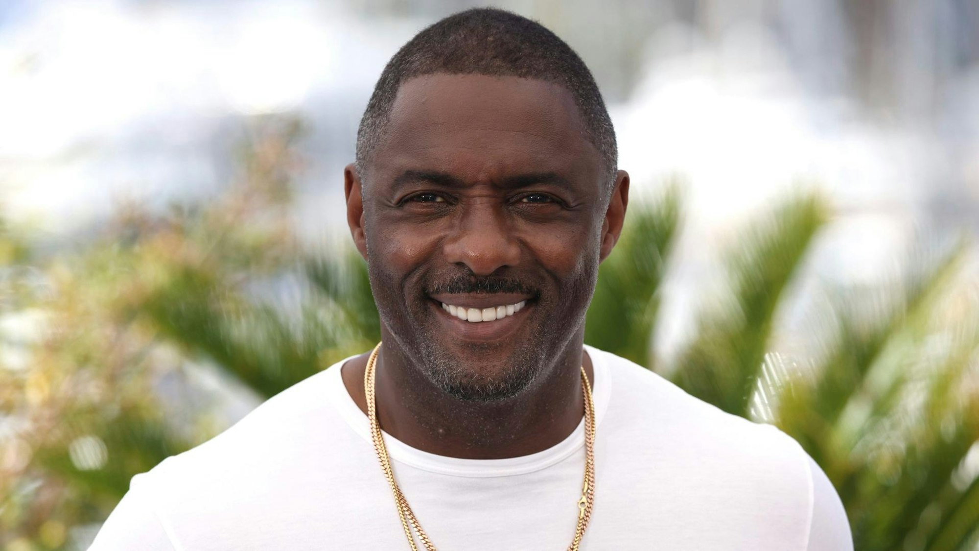 Idris Elba lacht in die Kamera.