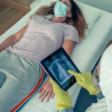 Corona-Patientin mit Arzt in Schutzkleidung