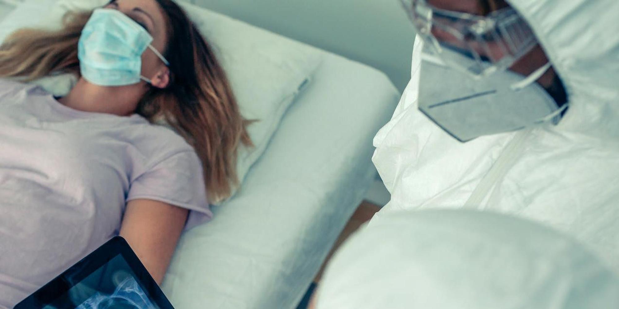 Corona-Patientin mit Arzt in Schutzkleidung