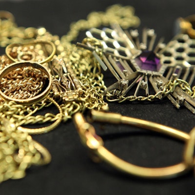Verschiedene Schmuckstücke aus Gold liegen auf einem Tisch.