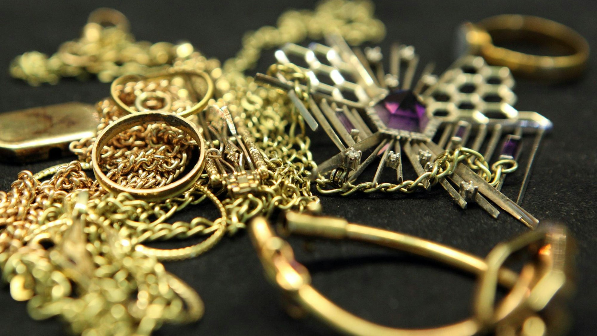 Verschiedene Schmuckstücke aus Gold liegen auf einem Tisch.