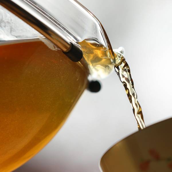Kräutertee wird in eine Tasse gegossen