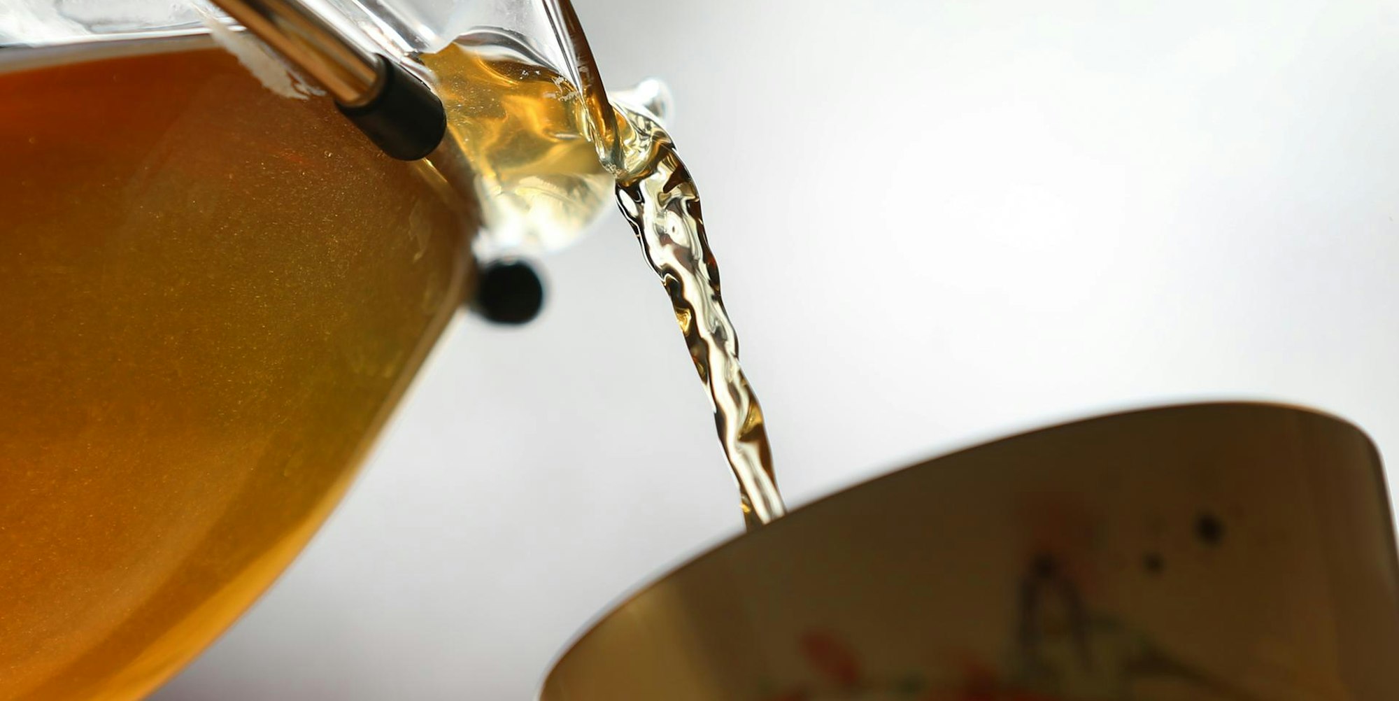 Kräutertee wird in eine Tasse gegossen