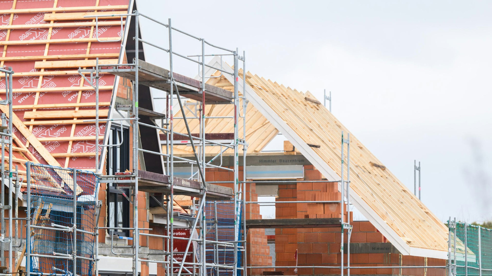Das Foto zeigt eine Baustelle mit zwei halbfertigen Wohnhäusern.